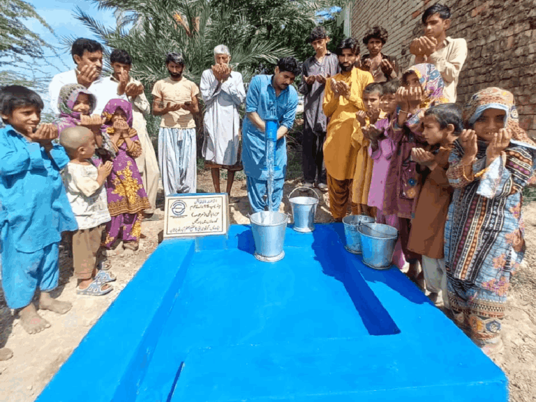 Community praying near the handpump donated by supporters.