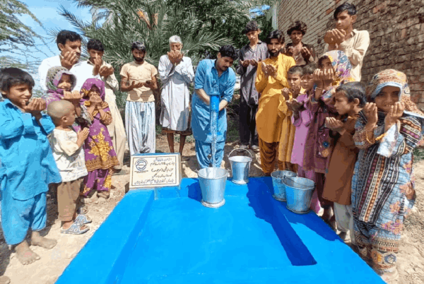 Community praying near the handpump donated by supporters.