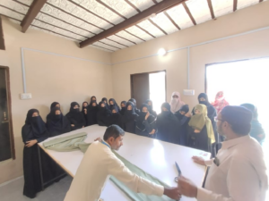 Students and the teacher are standing to conduct a practical class on stitching.